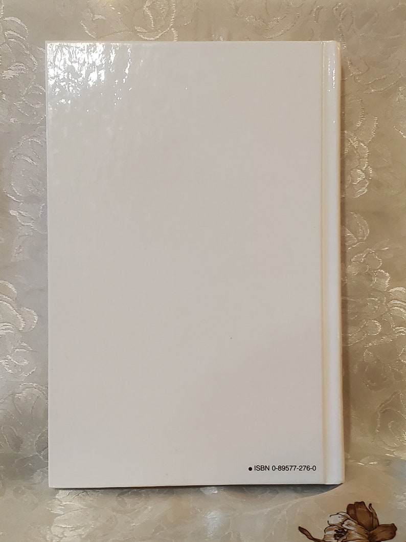 May include: White book with a glossy cover and black text on the back that reads "ISBN 0-89577-276-0".