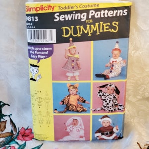 May include: A Simplicity Sewing Patterns for Dummies book with a yellow and black cover. The book features six different toddler costume patterns, including a clown, tiger, dog, bunny, and Santa Claus. The book is titled "Sewing Patterns for Dummies" and has the number 9813 on the cover.