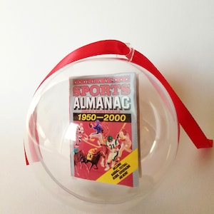 Pallina di Natale mini Grays Sports Almanac. Contiene la miniatura dell'almanacco sportivo visto in Ritorno Al Futuro - mini prop replica