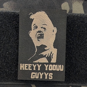 May include: A black and white patch with a cartoon character with a large head and the text "HEEY YOOOU GUYYYS".