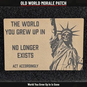 May include: A rectangular morale patch in tan with black text and a graphic. The text reads: THE WORLD YOU GREW UP IN NO LONGER EXISTS ACT ACCORDINGLY. To the right is a graphic of the Statue of Liberty depicted with a skull for a face.