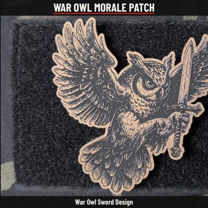 May include: A morale patch featuring a tan and black graphic of an owl with wings spread wide, clutching a sword in its talons. The design is set against a black hook-and-loop backing. The text WAR OWL MORALE PATCH and War Owl Sword Design appear.