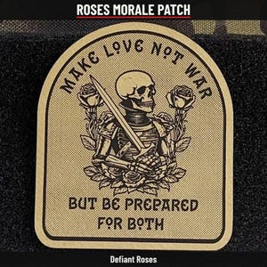 May include: A tan morale patch featuring a skeleton in armor holding a sword, surrounded by roses. The text reads: MAKE LOVE NOT WAR BUT BE PREPARED FOR BOTH. The patch has a dark border and a textured surface, set against a black background.