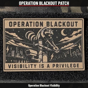May include: A rectangular morale patch featuring a tan background with black ink illustrations. It depicts a raccoon on a utility pole cutting power lines above a city skyline. Text reads OPERATION BLACKOUT and VISIBILITY IS A PRIVILEGE.