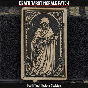 May include: A rectangular morale patch featuring a tan and black graphic of a hooded skeleton in a robe, holding a staff. The design is framed by an ornate border. Text at the top reads DEATH TAROT MORALE PATCH and at the bottom DEATH TAROT MEDIEVAL SKELETON.