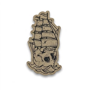 May include: A die-cut sticker featuring a ship with sails, designed as a skull sailing on waves. The artwork is in black ink on a tan background, with a slight drop shadow.