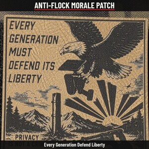May include: A square morale patch with a tan background and black ink illustration. It features a bald eagle carrying a camera, with the text: EVERY GENERATION MUST DEFEND ITS LIBERTY. Below, a landscape shows mountains, a sunburst, and a camera.