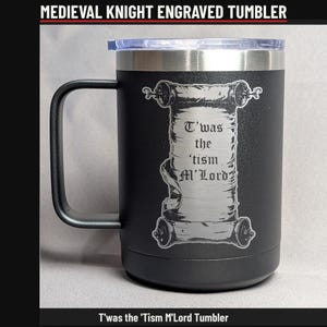 May include: A matte black stainless steel tumbler with a handle and a clear lid. The front features a laser-engraved scroll design with the text T'was the 'tism M'Lord. The tumbler has a cylindrical body and a metallic rim.
