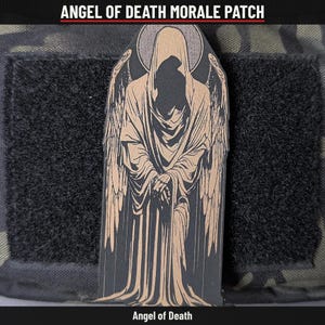 May include: A black and tan morale patch featuring a hooded figure with large wings and a halo, labelled ANGEL OF DEATH MORALE PATCH at the top and Angel of Death at the bottom. The design depicts a cloaked entity with folded hands.