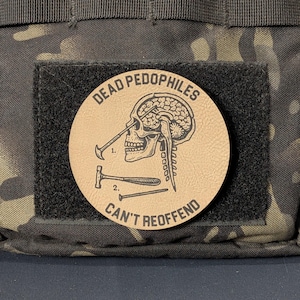 May include: A circular tan morale patch featuring a black line art illustration of a human skull with a tool inserted into the eye socket. The text reads DEAD PEDOPHILES CAN'T REOFFEND, with numbered diagrams of tools below the skull.