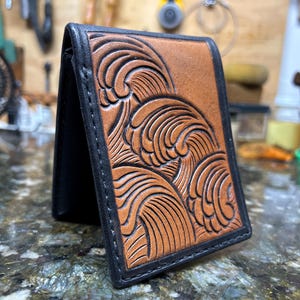 Cartera plegable de cuero hecha a mano con ondas tribales, palmera y flor de hibisco.