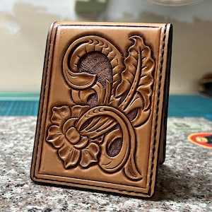 Cartera plegable de cuero repujado a mano con diseño floral y tejido de canasta