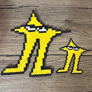 May include: Two yellow pixel art figures, each in the shape of a star with legs and arms, wearing sunglasses. The larger figure is approximately 25 cm tall, and the smaller one is about 13 cm tall. Both figures have black outlines.