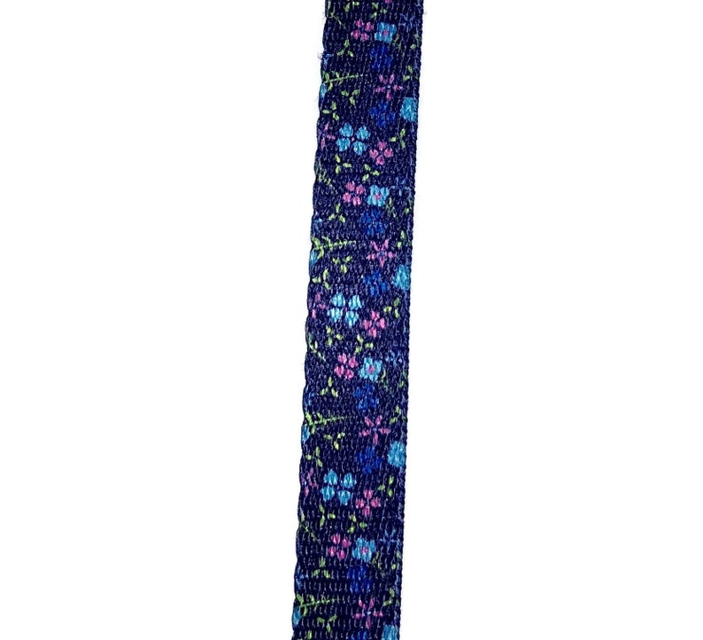 May include: A close-up of a dark blue ribbon with a floral pattern in shades of pink, blue, and green.