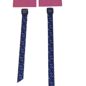 May include: Two blue and pink patterned straps with black buckles. The straps are 9.5 inches and 11 inches long.