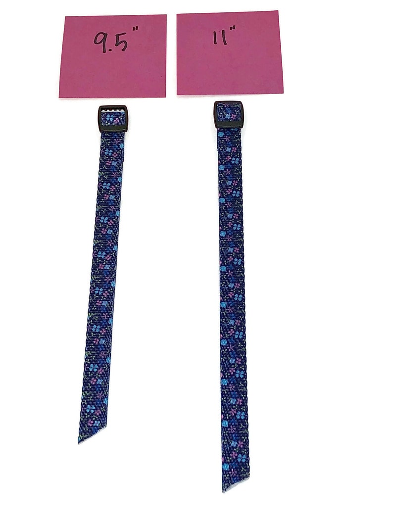 May include: Two blue and pink patterned straps with black buckles. The straps are 9.5 inches and 11 inches long.