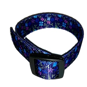 May include: A blue adjustable collar with a floral pattern and a black plastic buckle.