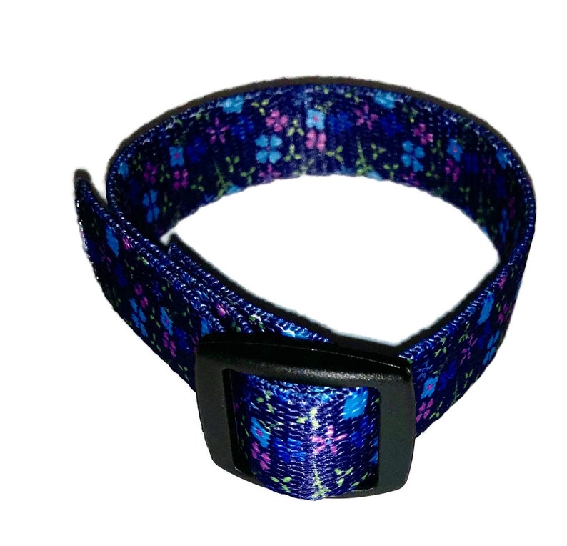 May include: A blue adjustable collar with a floral pattern and a black plastic buckle.
