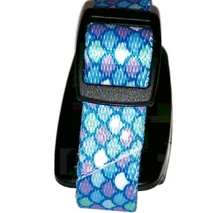 Peut inclure: Un collier pour chien &agrave; motif bleu et violet avec une boucle noire.