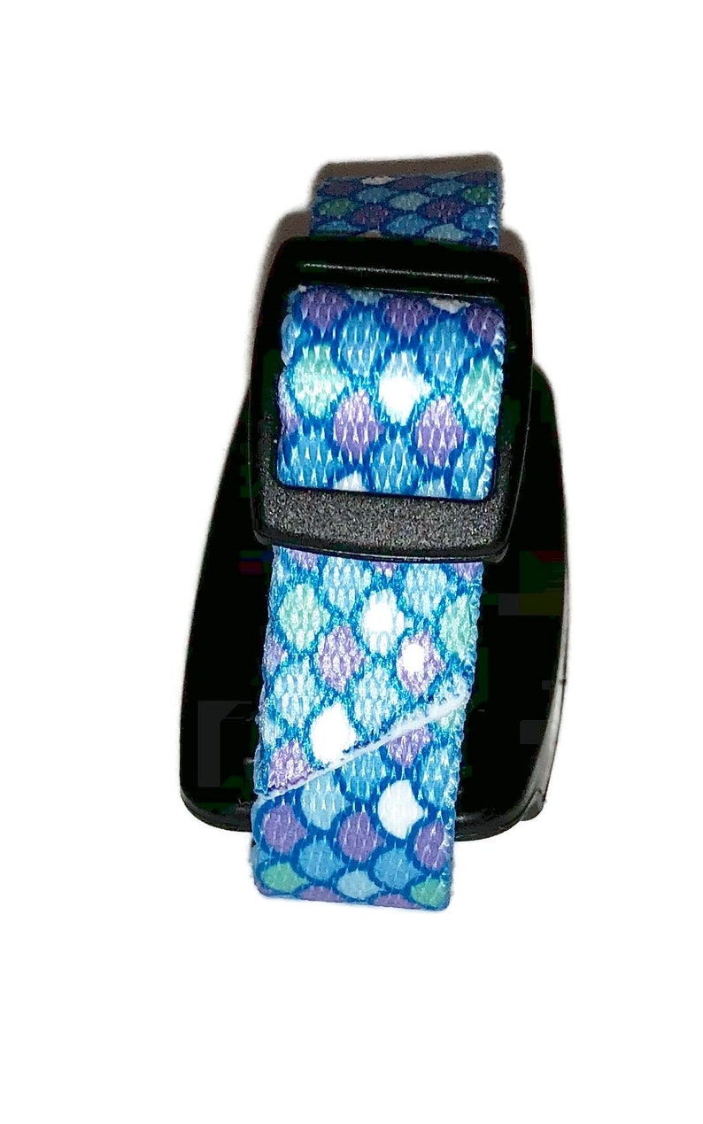 Peut inclure: Un collier pour chien &agrave; motif bleu et violet avec une boucle noire.