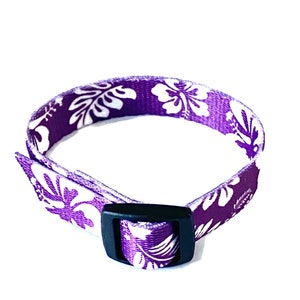 May include: Purple adjustable collar with a white floral pattern. The collar has a black plastic buckle.