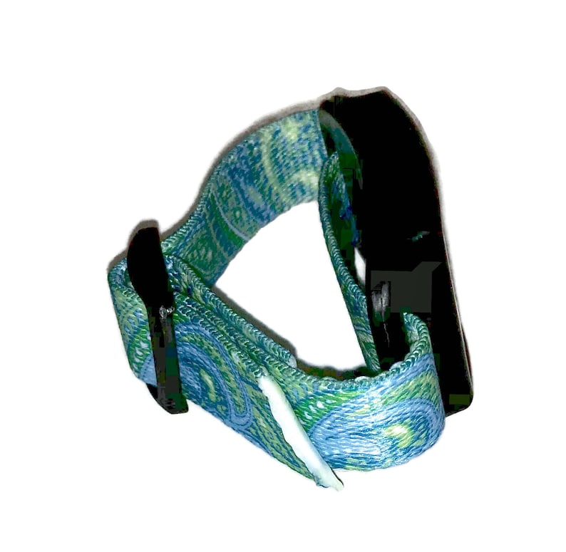 May include: A blue and green patterned adjustable wrist strap with a black plastic buckle.