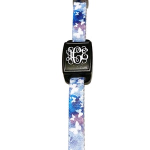 May include: A black and white monogrammed key chain with a blue and white butterfly pattern.