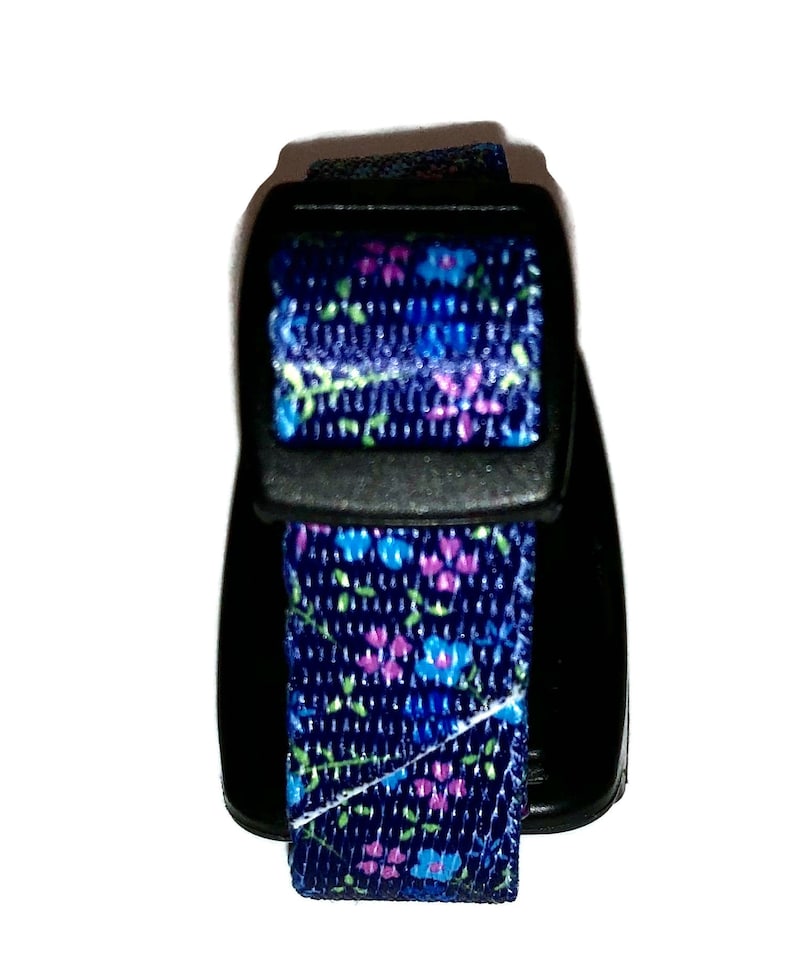 May include: A black and blue adjustable collar with a floral pattern. The collar has a plastic buckle.