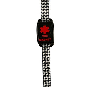 Puede incluir: Pulsera con estampado en blanco y negro con un im&aacute;n de alerta m&eacute;dica negro. El im&aacute;n tiene un s&iacute;mbolo de estrella de la vida roja y el texto "VNS MAGNET".