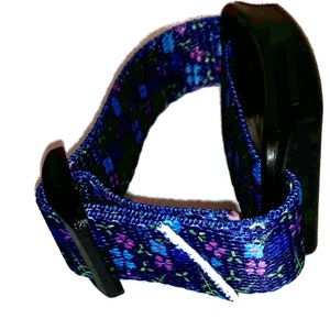 May include: A blue and purple floral patterned wristband with a black plastic buckle.