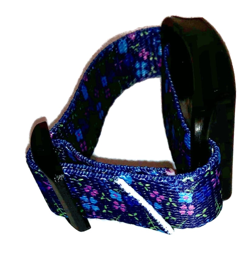 May include: A blue and purple floral patterned wristband with a black plastic buckle.