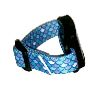 Peut inclure: Un bracelet de poignet r&eacute;glable bleu et violet avec une boucle noire. Le bracelet est en tissu et pr&eacute;sente un motif d'&eacute;cailles de sir&egrave;ne.