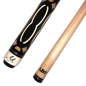 May include: A black and brown pool cue with a green and gold inlay design. The cue has a black and white "AA" logo on the butt end and a black and white "LD1" logo on the tip end.
