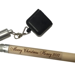May include: A wooden pool cue tip with a black tip and a silver metal base. The cue tip is engraved with the text "Merry Christmas Honey 2017". A black chalk holder is attached to the cue tip with a silver chain.