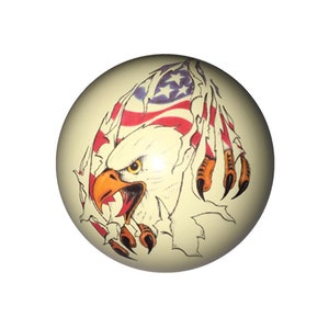 May include: A white billiard ball with a graphic of an American bald eagle with its talons tearing through an American flag.