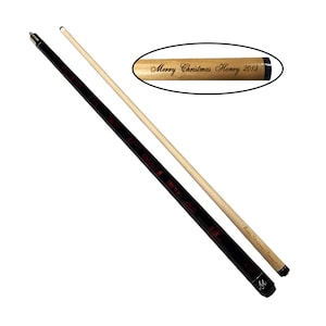 May include: A black and red pool cue with a white tip and a brown wooden shaft. The shaft is engraved with the text "Merry Christmas Honey 2013".