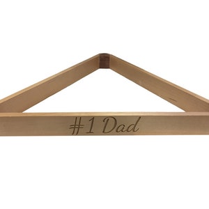Könnte beinhalten: Ein Billard-Dreiecksgestell aus Holz mit dem eingravierten Text "#1 Dad" auf der Basis.