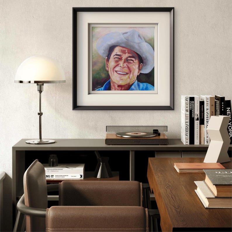 President Ronald Reagan
Titled “Power To The People”
Museum-Quality Fine Art Prints on Canvas & Archival Paper 
from an Original Hand-Painted Artwork by Marnie Miller (Texas, b. 1971)

This warm, charismatic portrait captures President Ronald Reagan in a way few images ever have—not as a distant politician, but as the genuine, approachable man the world came to love. Dressed in his iconic ranch attire, wearing a cowboy hat and faded Wrangler denim shirt, Reagan appears relaxed, confident smile.