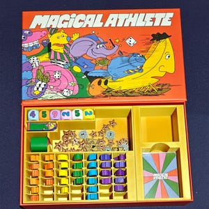 May include: A vintage board game titled "MAGICAL ATHLETE" with a colorful cartoon design on the lid. The game box is open, revealing game pieces, dice, and cards in various colors, including orange, yellow, green, and blue. The game appears to be complete.