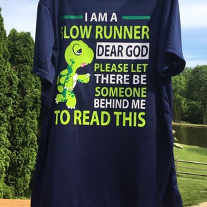 Puede incluir: Una camiseta azul marino con un gr&aacute;fico de tortuga verde y el texto "Soy un corredor lento. Dios m&iacute;o, por favor, que haya alguien detr&aacute;s de m&iacute; para leer esto."