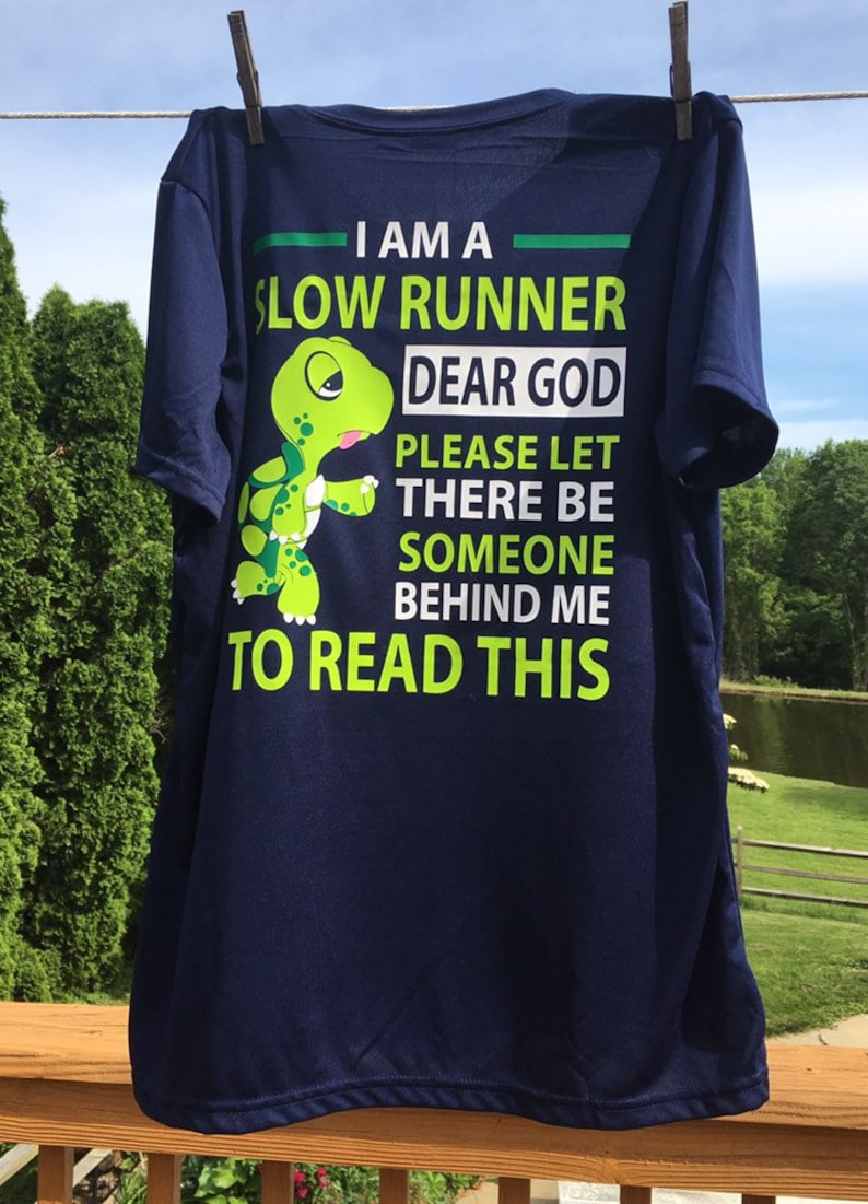 Puede incluir: Una camiseta azul marino con un gr&aacute;fico de tortuga verde y el texto "Soy un corredor lento. Dios m&iacute;o, por favor, que haya alguien detr&aacute;s de m&iacute; para leer esto."