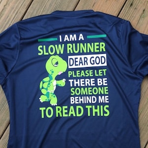 Puede incluir: Una camiseta azul marino con una tortuga verde de dibujos animados y el texto "Soy un corredor lento. Dios m&iacute;o, por favor, que haya alguien detr&aacute;s de m&iacute; para leer esto."