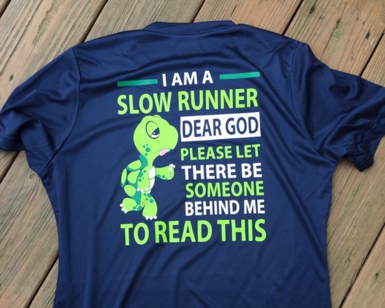Puede incluir: Una camiseta azul marino con una tortuga verde de dibujos animados y el texto "Soy un corredor lento. Dios m&iacute;o, por favor, que haya alguien detr&aacute;s de m&iacute; para leer esto."