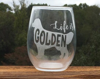 May include: A clear glass wine glass with the text "Life is GOLDEN" etched on the side. A silhouette of a golden retriever is also etched on the glass.