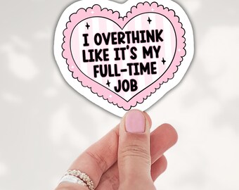 May include: A heart-shaped sticker with a scalloped pink border and a light pink and white striped background. The text reads I OVERTHINK LIKE IT'S MY FULL-TIME JOB in bold black letters, accented by small black four-pointed star icons.