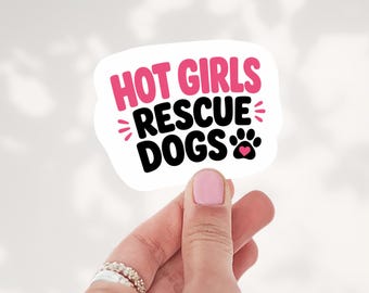 May include: A white die-cut sticker with the text HOT GIRLS in pink and RESCUE DOGS in black. The design includes small pink accent lines and a black paw print icon featuring a small pink heart in the center of the paw pad.