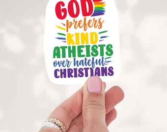 May include: A white rectangular sticker with rounded corners featuring the text GOD prefers KIND ATHEISTS over hateful CHRISTIANS in various colors including red, orange, yellow, green, blue, and purple with a rainbow brush stroke.