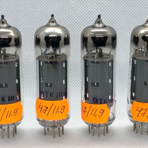 Peut inclure: Quatre tubes à vide argentés avec des étiquettes noires et des autocollants orange. Les étiquettes indiquent "OTK" et les autocollants indiquent "47/119".