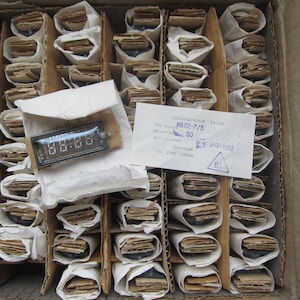 K&ouml;nnte beinhalten: Eine Schachtel gef&uuml;llt mit einzeln verpackten elektronischen Bauteilen. Die Schachtel ist mit "Электронный талон" beschriftet, mit dem Text "ИВЛ2-7/5" und "5-WCH 1992".