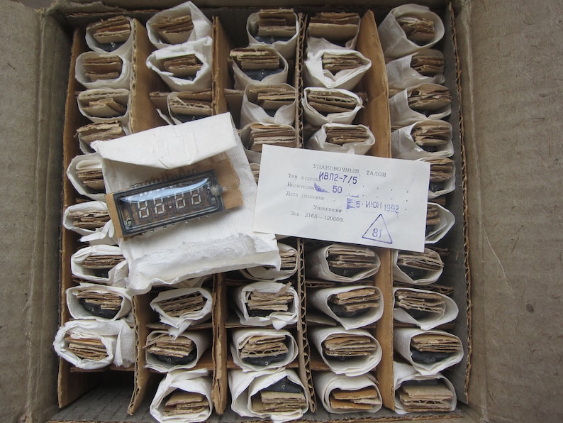 K&ouml;nnte beinhalten: Eine Schachtel gef&uuml;llt mit einzeln verpackten elektronischen Bauteilen. Die Schachtel ist mit "Электронный талон" beschriftet, mit dem Text "ИВЛ2-7/5" und "5-WCH 1992".